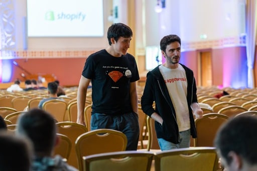 Two men in AppTweak shirts leave the congress hall
