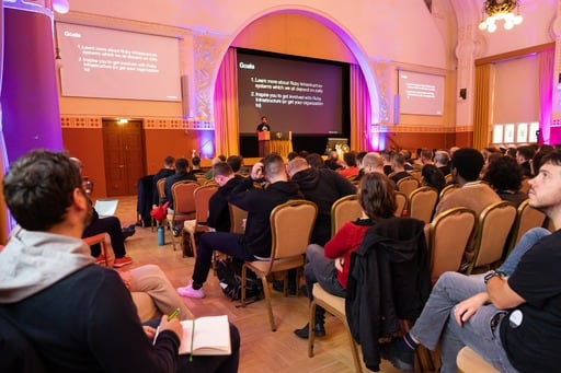 Adarsh Pandit presenting his talk, audience in foreground