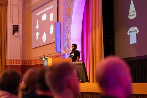 Adarsh Pandit presenting his talk, audience in foreground